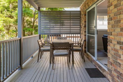a patio with a table and chairs on a porch at Billie's on Smiths in Smiths Lake