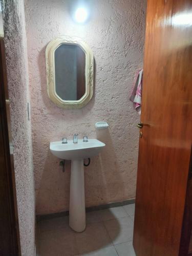 a bathroom with a sink and a mirror on the wall at Cabañas El Rosedal in San Rafael