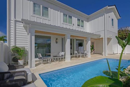a house with a swimming pool and a patio at Seaside Cottage Sumuide in Nago