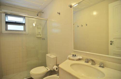 ein Badezimmer mit einem Waschbecken, einem WC und einem Spiegel in der Unterkunft Pousada Dos Búzios in Búzios