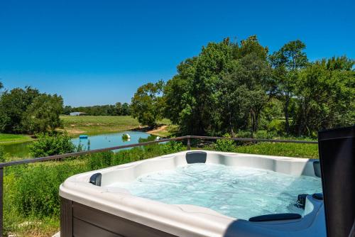 a hot tub with a view of a river at The June Hot tub with king beds on 2 acres in Hot Springs