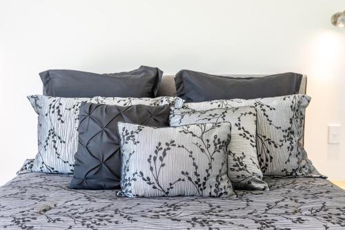 a group of pillows on a bed at The Lakeside - Tauranga Holiday Home in Tauranga