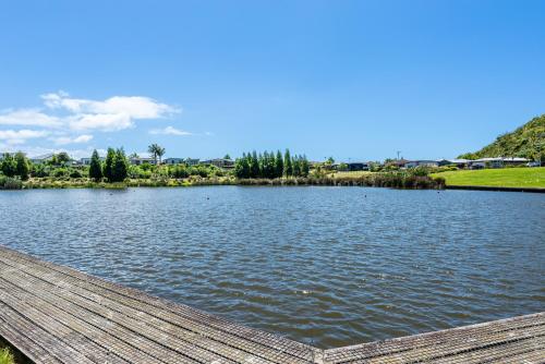 a view of a lake with a wooden dock at The Lakeside - Tauranga Holiday Home in Tauranga