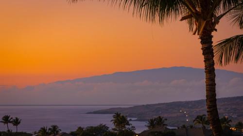 a view of the ocean and palm trees at sunset at ❤PiH❤ Mauna Kea SunsetsOcean and Golf ViewsOptional Mauna Kea Hotel Privileges in Hapuna Beach