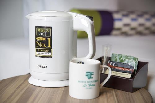 a coffee maker and a mug on a table at Hotel Monterey Le Frere Osaka in Osaka