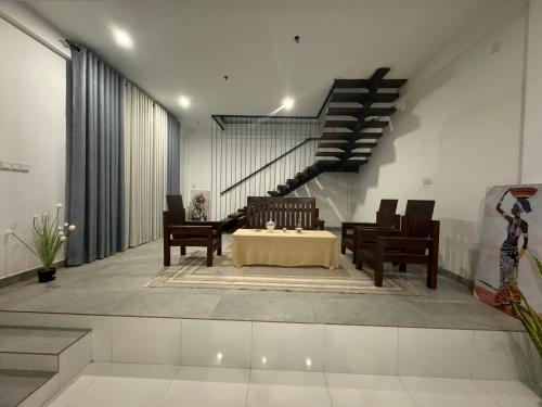 a room with a table and chairs and a staircase at Pearl White Residency-HOTEL in Polonnaruwa