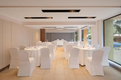 a banquet hall with white tables and white chairs at Fairfield by Marriott Goa Anjuna in Anjuna