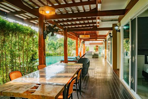 an outdoor dining area with a wooden table and chairs at Farinda Resort & Pool Villa in Ban Huai Muang