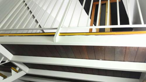 a white staircase with yellow and white rails at Dolce Pace Kreyol in Cayenne