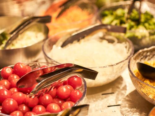 a table topped with bowls of tomatoes and other foods at Kansai Airport Washington Hotel in Izumi-Sano