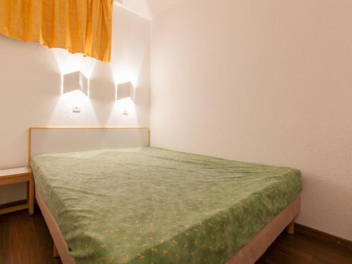 - une petite chambre avec un lit et une couverture verte dans l'établissement Appartement 2 pièces pour 5 personnes avec balcon à Avoriaz - FR-1-314-287, à Morzine