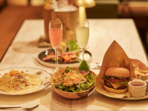 a table with plates of food and glasses of wine at Kansai Airport Washington Hotel in Izumi-Sano