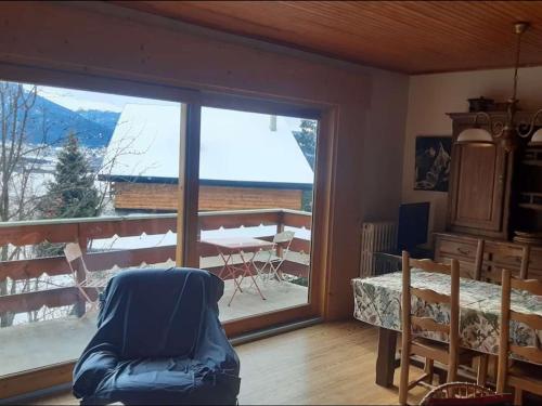 un salon avec une grande fenêtre et une table avec vue dans l'établissement Chalet calme 11 pers. rénové, proche pistes, jardin, parking - FR-1-592-77, à Bolquère-Pyrénées 2000