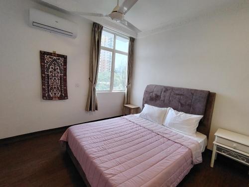 a bedroom with a bed with a pink blanket and a window at Venice Hill Cheras SunriseCorner in Cheras