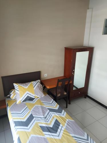 a bedroom with a bed and a desk and a mirror at Penginapan PIP Semarang in Jomblang