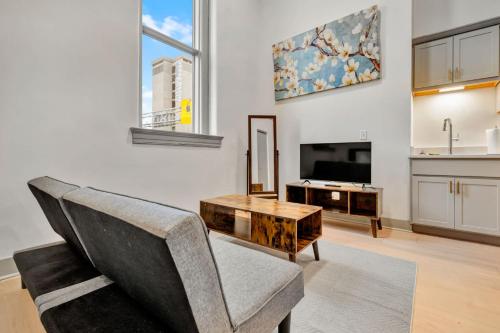 a living room with a chair and a table at Bright and Modern Studio in Louisville # 304 in Louisville