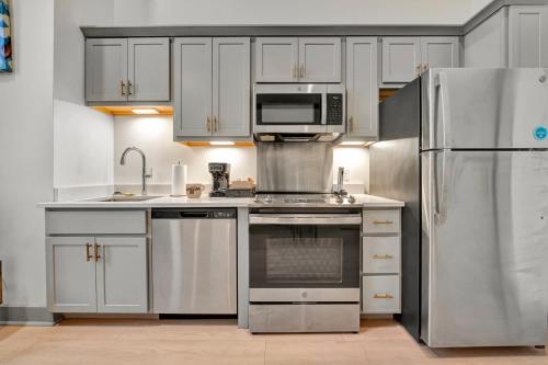 a kitchen with white cabinets and stainless steel appliances at Bright and Modern Studio in Louisville # 304 in Louisville