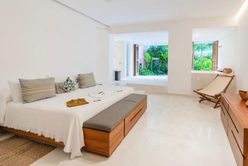 a bedroom with a large bed and a large window at El Careyes Club & Residences in Careyes