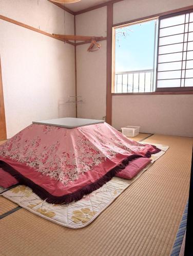 a large bed in a room with a large window at KANEKAKU in Hakuba