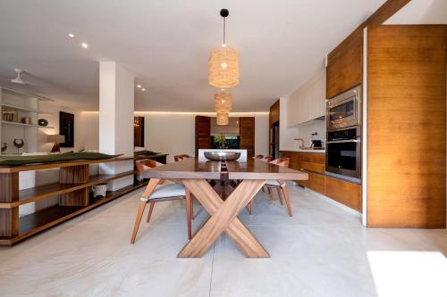 a kitchen and dining room with a wooden table at El Careyes Club & Residences in Careyes