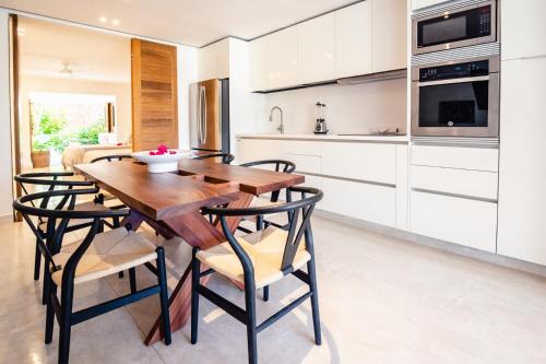 a kitchen with a wooden dining table and chairs at El Careyes Club & Residences in Careyes