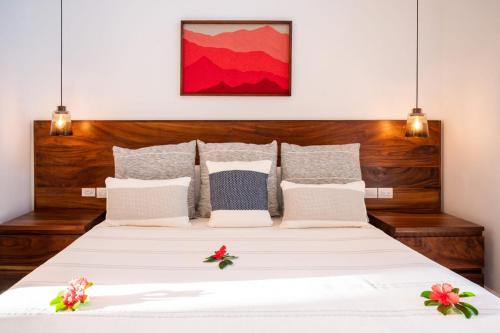 a bedroom with a large white bed with two lights at El Careyes Club & Residences in Careyes