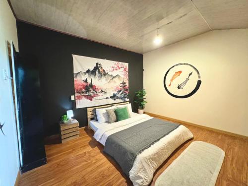a bedroom with a bed and a painting on the wall at SAKURA House ĐÀ LẠT in Da Lat