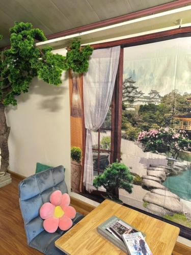 a living room with a table and a large window at SAKURA House ĐÀ LẠT in Da Lat