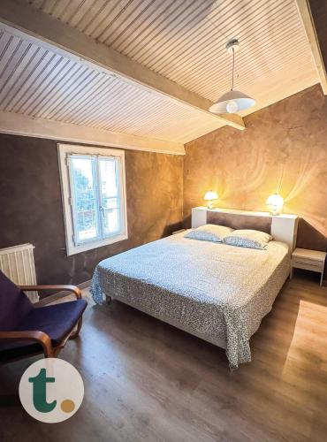 une chambre avec un grand lit et une chaise dans l'établissement Tranquiloue - Grande maison spacieuse - PuyduFou, aux Herbiers