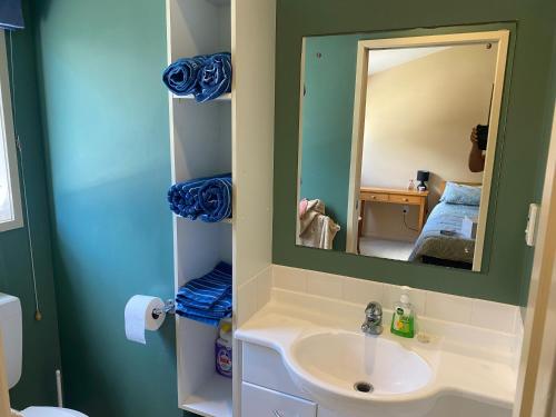 a bathroom with a sink and a mirror at Beach Break in Mount Maunganui
