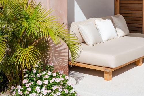 a white couch sitting on a patio with flowers at El Careyes Club & Residences in Careyes