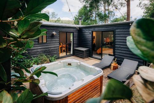 a hot tub in the backyard of a house at Mystwood Spa Cabins in Wollombi