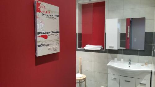 baño con lavabo y pared roja en Hôtel Restaurant Les Chasseurs, en Marine de Pietracorbara