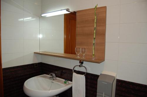 a bathroom with a sink and a mirror and a towel at Hotel Diego in Santa Bárbara