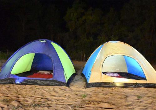 two tents sitting on the beach at night at Gokarna Glimpse Getaway in Gokarna