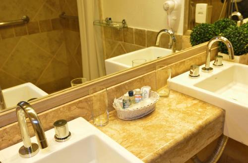 a bathroom with a sink and a mirror at Pousada Dos Búzios in Búzios