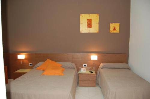 2 camas en una habitación pequeña con 2 lámparas en Hotel Diego, en Santa Bárbara