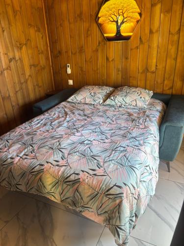 a bed with a comforter in a room at Bungalow Combava in Saint-Pierre