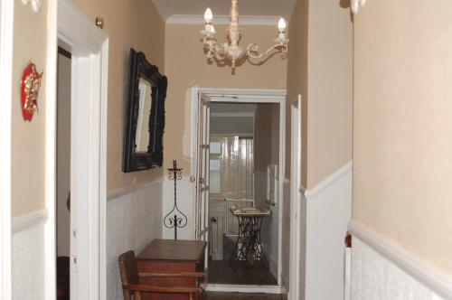 a hallway with a table and a chandelier at Knights Rest in Shanklin