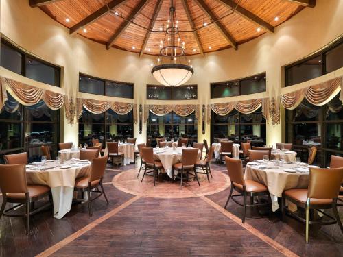a dining room with tables and chairs and a chandelier at Flying Horse Resort & Club in Colorado Springs