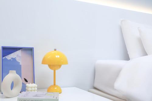 a table with a lamp and a picture on it at Landmark Stay in Songdo in Incheon
