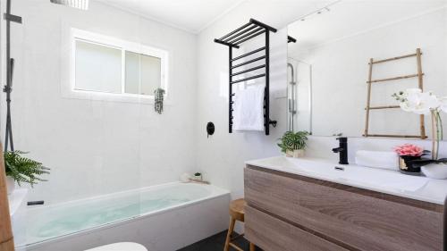 ein Badezimmer mit Badewanne und Waschbecken in der Unterkunft Coastal Palms in Culburra Beach