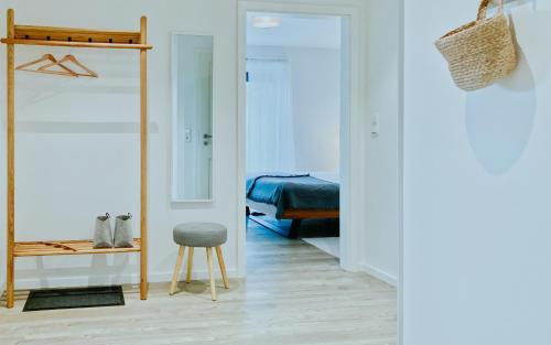 a room with a mirror and a stool and a bedroom at Himmelsicht in Westerdeichstrich