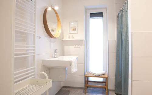 a white bathroom with a sink and a mirror at Himmelsicht in Westerdeichstrich