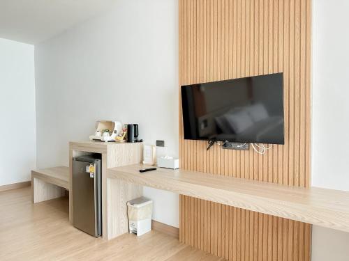 カノムにある2SIS'S Khanom Resotelの木製の壁にテレビ付きのリビングルーム