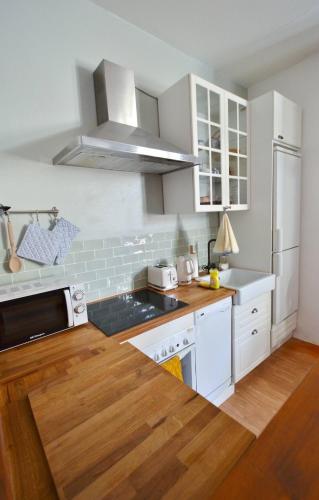 une cuisine avec des appareils électroménagers blancs et du parquet dans l'établissement garazi, à Saint-Jean-Pied-de-Port