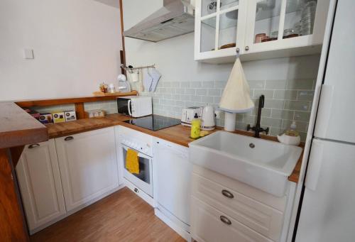 a small kitchen with white cabinets and a sink at garazi in Saint-Jean-Pied-de-Port