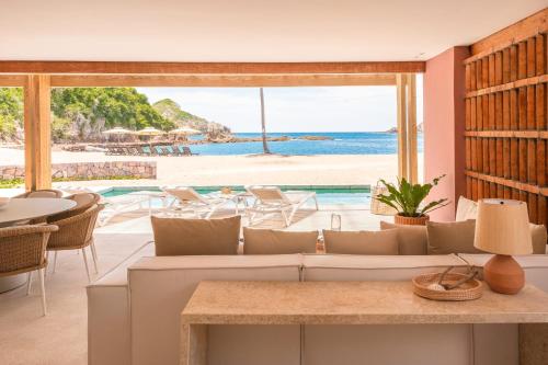 a living room with a couch and a view of the ocean at El Careyes Club & Residences in Careyes