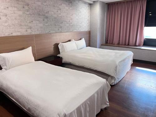 a hotel room with two beds and a window at 嘉樂行旅Gala Inn in Tainan