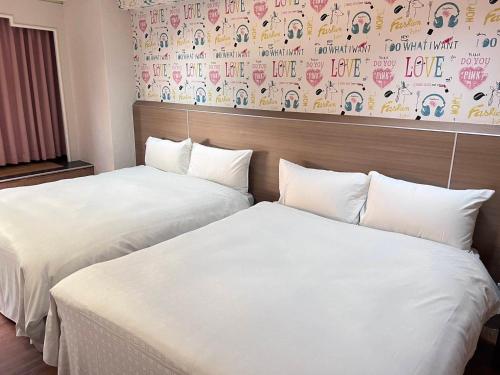 two beds sitting next to each other in a hotel room at 嘉樂行旅Gala Inn in Tainan